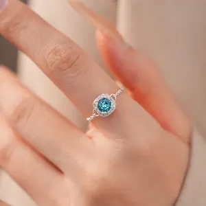 Detaillierte Nahaufnahme eines silbernen Rings mit funkelndem blauem Zirkon.