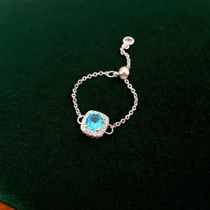 Detail eines verstellbaren Kettenrings mit hellblauem Zirkon und Halo-Fassung