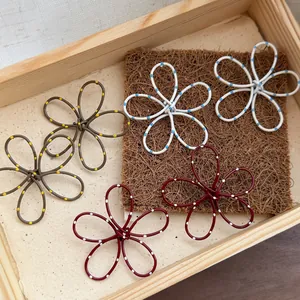 Macro shot of assorted 3D wire flower earrings with colorful polka dots in a tray