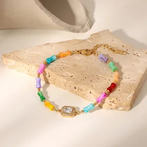 Macro detail showing colorful dopamine bamboo beads and a sparkling CZ pendant on a gold bracelet