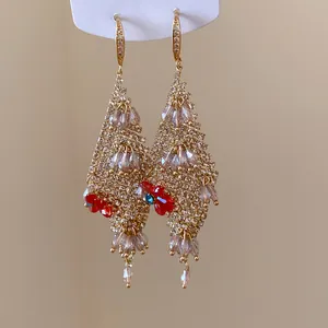 Ornate gold-tone drop earrings with sparkling rhinestones and red flower accents.
