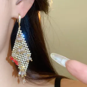 Close-up macro view of sparkling rhinestone tassel earrings featuring red flower accent