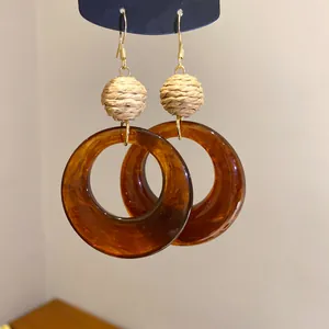 Detailaufnahme der Vintage-Bernstein-Acrylohrringe mit elegantem Bastballdetail