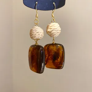 Detailansicht der Vintage-Ohrringe mit braunem Acrylquadrat und gewebter Perle