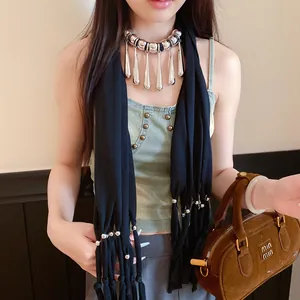 Gros plan d'un collier écharpe bohème en tissu avec glands en forme de goutte