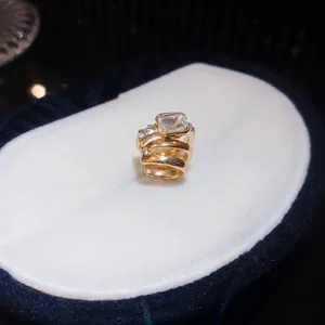Nahaufnahme eines eleganten Gold-Zirkonia-Ohrclips mit funkelnden Steinen