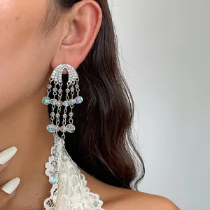 Detailopname van elegante zilveren kwastjes oorbellen met iriserende kralen en stras