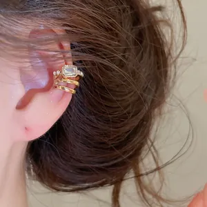 Nahaufnahme eines eleganten goldenen Ohrmanschetten mit einem strahlenden Zirkoniastein.