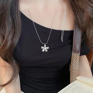 Silver flower pendant necklace for women worn on a minimalist black top detail view