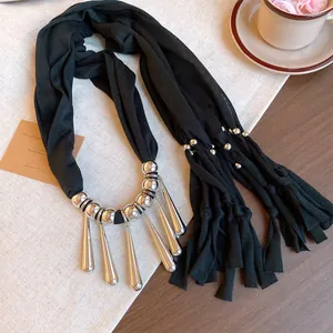 Détail de collier en tissu bohème avec des franges en forme de gouttes argentées