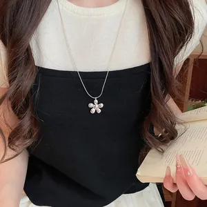 Detailed view of silver flower pendant on a minimalist clavicle chain necklace