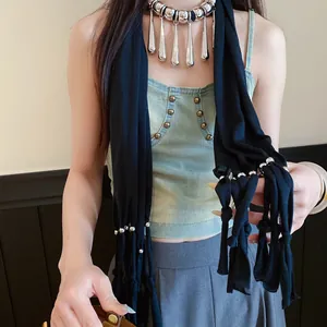 Détail du collier en tissu bohème avec franges à pampilles argentées sur un modèle