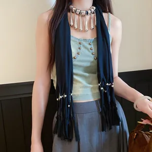 Détail d'un collier écharpe en tissu bohème avec franges gouttes d'argent sur modèle.