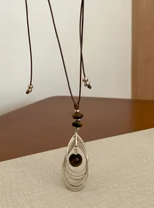 Gedetailleerde weergave van de zilveren druppelhanger met een bruine tijgeroog steen