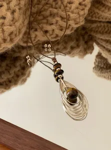 Macroweergave van vintage tijgeroog hanger met meerlaags zilveren druppelontwerp