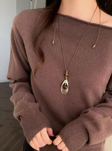 Gedetailleerde opname van een retro tijgeroog hanger aan een bruine leren koordketting