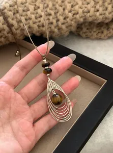 Detail van tijgeroog hanger ketting met vintage goudkleurig gelaagd druppelvormig frame