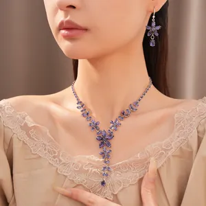 Close-up van een elegante paarse zirkoon bloem ketting en oorbellen set op een Aziatisch model