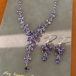 Detailopname van de elegante paarse zirkoon bloem en druppel sieradenset voor dames