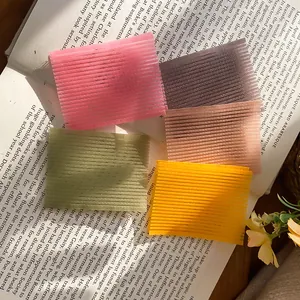 Close-up van vijf kleurrijke haargrip-pads gerangschikt op een open vintage boek