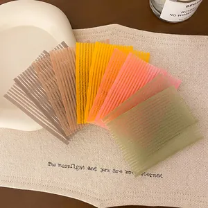 Gekleurde haarstickers voor het fixeren van pony en losse haren op een stoffen ondergrond.
