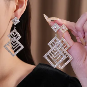 Elegante geometrische hohle Ohrhänger mit Diamantbesatz in Silber- und Goldtönen.