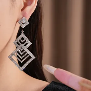 Nahaufnahme von eleganten hohl-diamantförmigen Strass-Ohrhängern bei einem Model