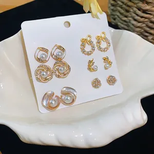 Elegante Franse set van 6 paar parel- en strass-gouden oorbellen in een witte schelp display