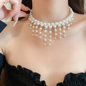 Detailed view of an elegant French style pearl choker with delicate tassels on a female model
