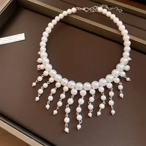 Detailed macro view of a French vintage pearl choker with elegant white tassel droplets