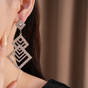 Detailansicht von luxuriösen Strass-Ohrringen in Rautenform, getragen am Ohr eines Models