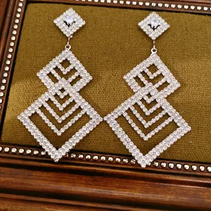 Nahaufnahme von eleganten geometrischen hohlen Ohrringen mit Strasssteinen aus Silber