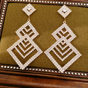 Elegante goldfarbene Ohrhänger mit funkelndem Strassstein im geometrischen Rauten-Design.