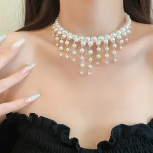 Close-up of elegant French style pearl choker with dangling tassel drop details.