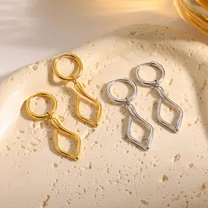 Detailansicht von goldenen und silbernen unregelmäßigen geometrischen Ohrringen.