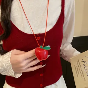 Nahaufnahme einer handgefertigten Apfel-Halskette aus rotem Leder auf einer Weste.
