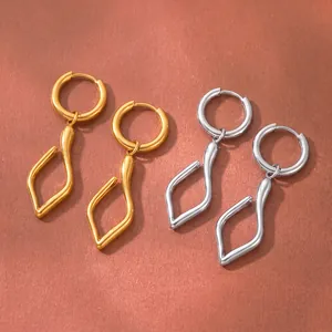 Nahaufnahme von unregelmäßigen minimalistischen Edelstahl-Ohrringen in Gold und Silber