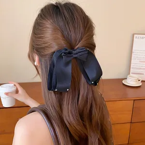 Achteraanzicht van een vrouw met een elegante zwarte stoffen haarkrik met strass-steentjes.