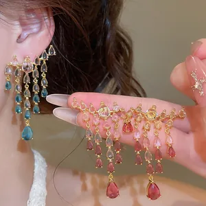 Gros plan d'élégantes boucles d'oreilles vintage en zircon avec pampilles colorées