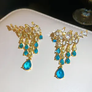 Vue détaillée de boucles d'oreilles vintage en or avec zircons bleus en forme de goutte