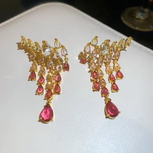Gros plan de boucles d'oreilles vintage en or avec glands de zircone colorés