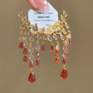 Gros plan de boucles d'oreilles vintage à pampilles dorées avec zircon rouge et argent 925