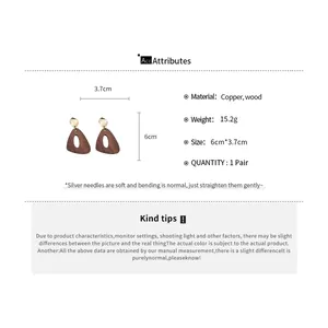Vue détaillée des boucles d'oreilles géométriques vintage en bois et cuivre avec tailles