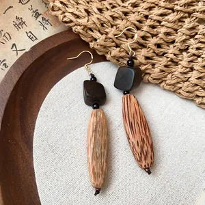 Détail de boucles d'oreilles ethniques en bois avec grain naturel style vintage