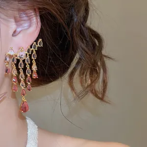 Gros plan de boucles d'oreilles vintage élégantes avec des pierres de zircone rose en goutte.