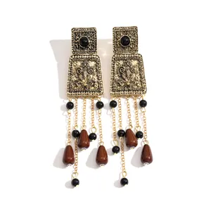 Vintage gold metal earrings with black beads and brown acrylic water drop tassels.