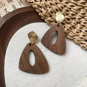 Vue détaillée de boucles d'oreilles vintage en bois au design triangle évidé