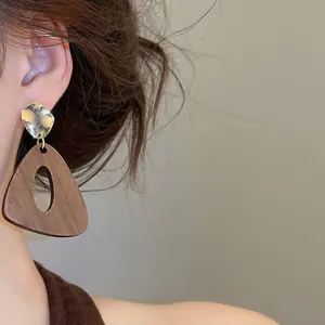 Gros plan détaillé de boucles d'oreilles géométriques en bois et métal style ethnique