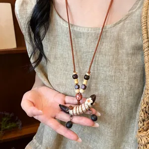 Gedetailleerde opname van een etnische houten erwtenpeul hanger ketting met kralen