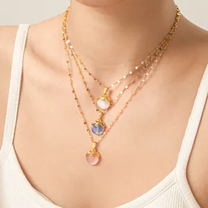 Detail view of natural cat eye stone pendants on layered gold titanium steel chains
